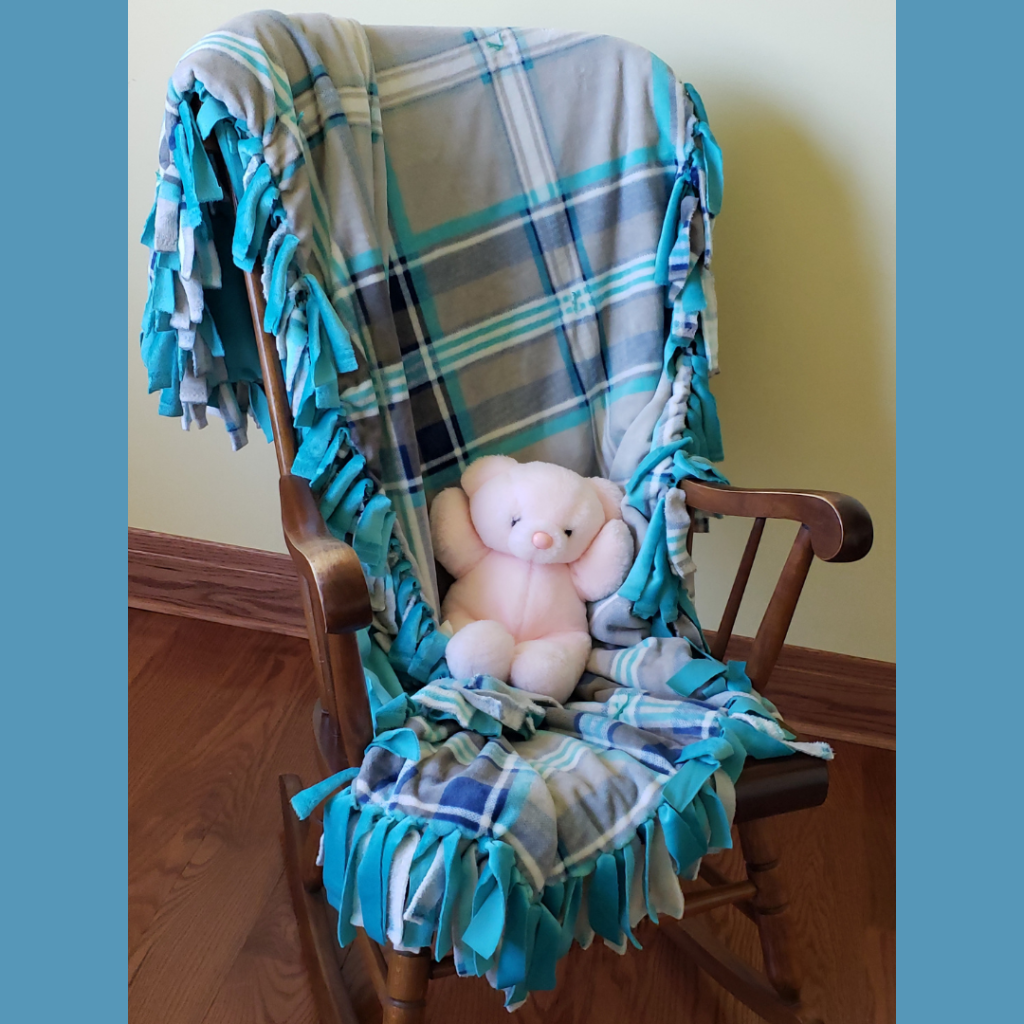 Teal, Blue, and White Tied Fleece Throw with pink teddy bear